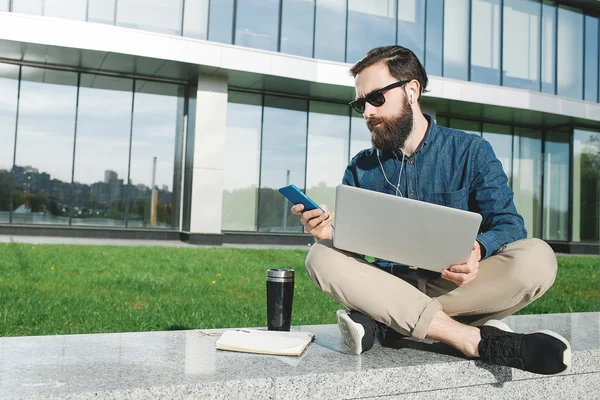 Empresario en gafas de sol con portátil haciendo llamada al aire libre —  Fotos de Stock