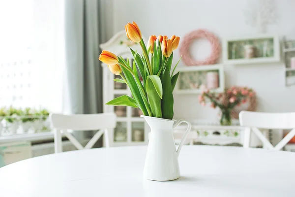 素朴な台所のテーブルの上に花瓶の美しいオレンジ色の花 — ストック写真