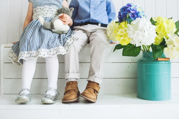 Babyjongen en meisje, zittend op een houten vloer — Stockfoto