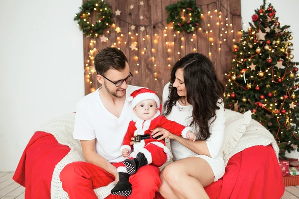 Hipster father and mother holding baby in santa suit — Stock Photo, Image