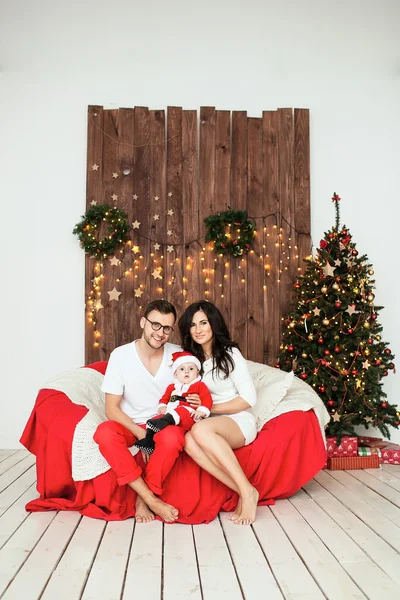 Hipster otec a matka drží dítě v obleku santa — Stock fotografie