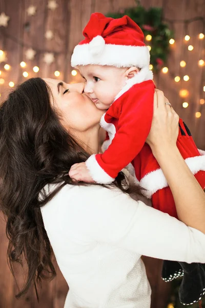 Young mother holding baby in santa suit — Stock Photo, Image