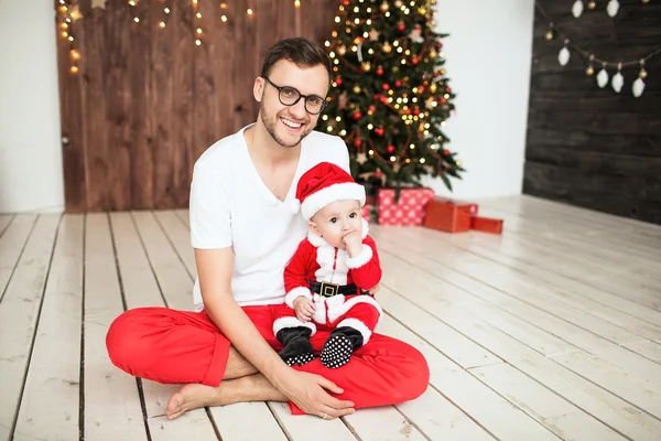 Hipster père tenant bébé en costume de Père Noël — Photo