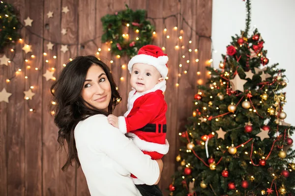 Jeune mère tenant bébé en costume de Père Noël — Photo