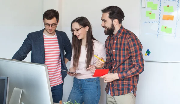 Equipo de tres colegas que trabajan en una oficina moderna —  Fotos de Stock