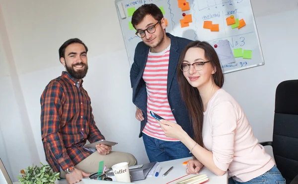 Equipo de tres colegas que trabajan en una oficina moderna —  Fotos de Stock