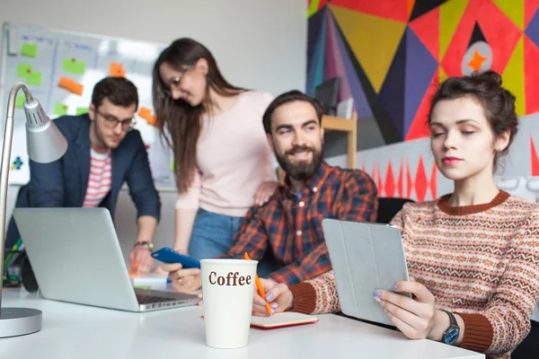 Équipe créative de quatre collègues travaillant dans un bureau moderne — Photo