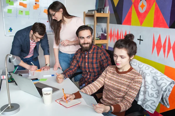 Équipe créative de quatre collègues travaillant dans un bureau moderne — Photo