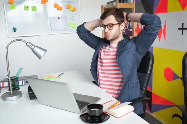 Sottolineato giovane maschio in ufficio moderno con laptop — Foto Stock