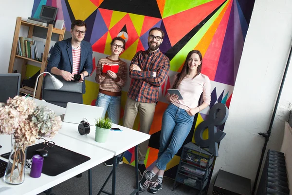 Creative team of four colleagues working in modern office — Stock Photo, Image