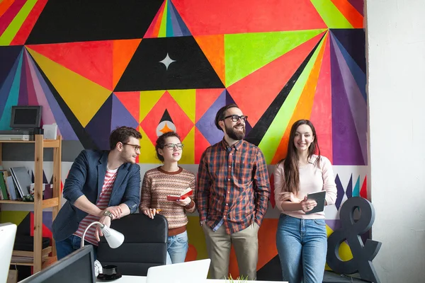 Creative team of four colleagues working in modern office — Stock Photo, Image