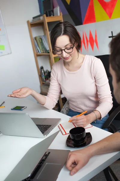 Young male discussing business with woman in modern office — Stock Photo, Image