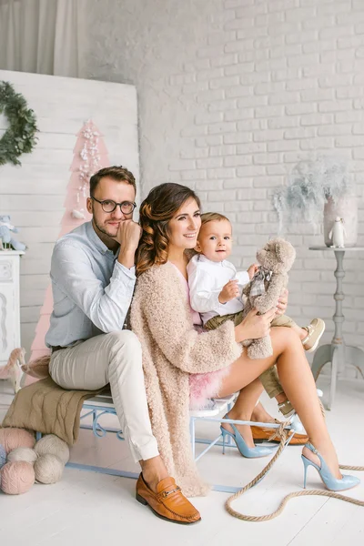 Young happy family with baby in christmas decor studio — Stock Photo, Image