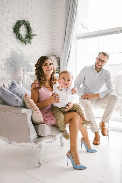 Pretty young family having fun in light decorated studio — Stock Photo, Image