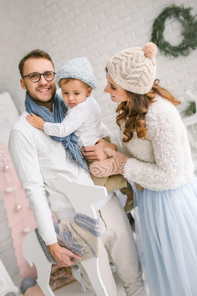 Happy young family smiling and hugging in bright loft studio — Stock Photo, Image