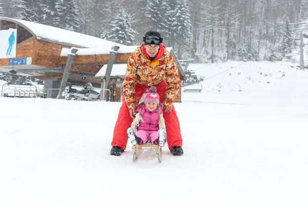 Otec a dcera pózuje v zimě saně — Stock fotografie