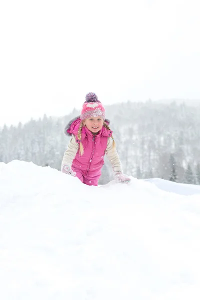 Lilla flickan glatt leker i snön — Stockfoto