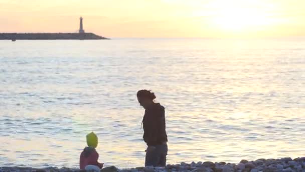 Anne ve çocuk denize taş atma — Stok video