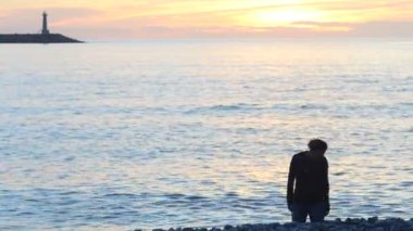 Anne ve çocuk denize taş atma