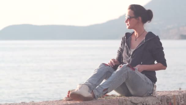 Vrouw met behulp van een tablet op het strand tijdens zonsondergang — Stockvideo
