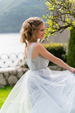 güzel genç gelin bir çimenlikte fotoğraf için poz veriyor.