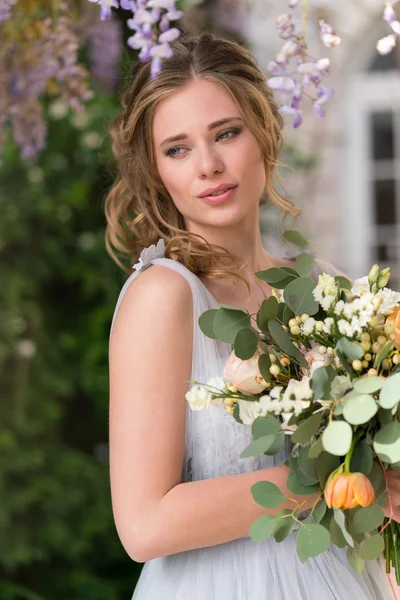 Jeune mariée portrait avec un bouquet de mariage — Photo