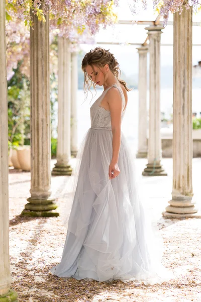 Jonge bruid in een trouwjurk met zich meebrengt op het terras — Stockfoto