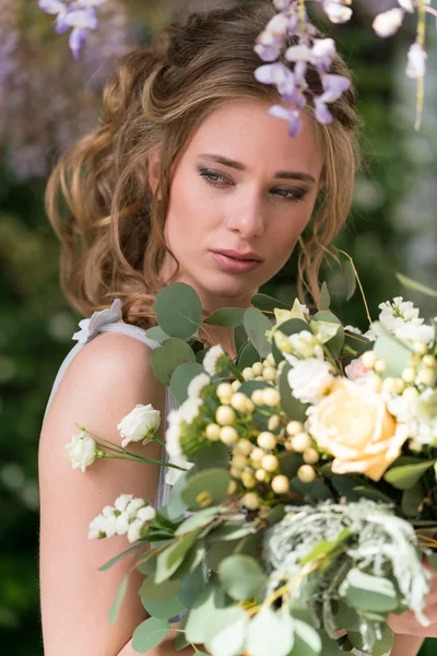 Jeune mariée portrait avec un bouquet de mariage — Photo