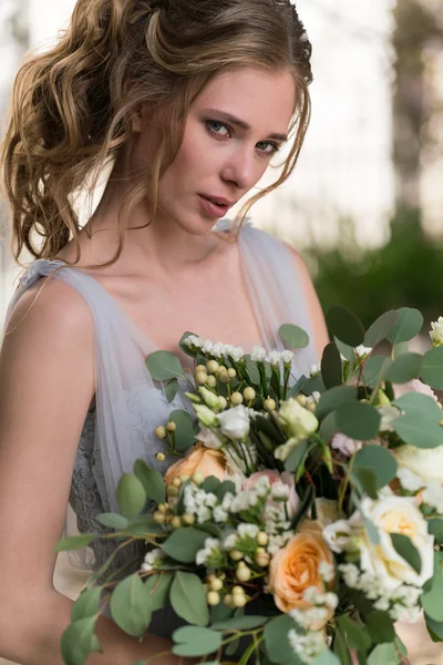 Jeune mariée portrait avec un bouquet de mariage — Photo