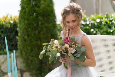 güzel genç gelin bir çimenlikte fotoğraf için poz veriyor.