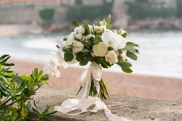 bridal bouquet of orchids, ranunculuses, tulips and eucalyptus