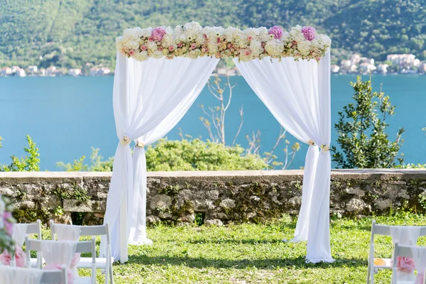 Arco per la cerimonia nuziale, decorato con stoffa e fiori — Foto Stock