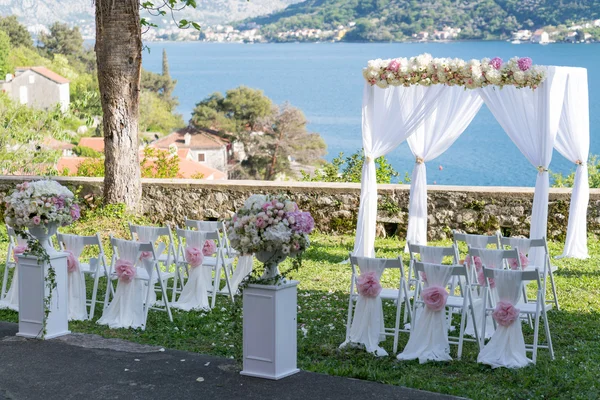 Bogen für die Hochzeitszeremonie, geschmückt mit Tuch und Blumen — Stockfoto