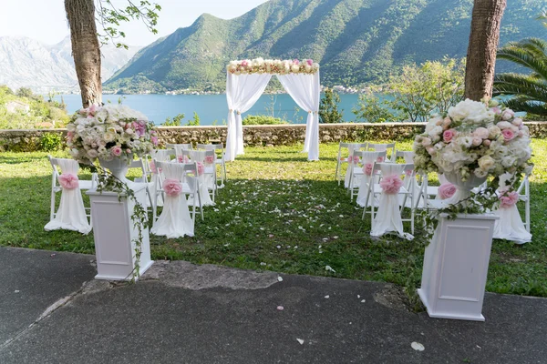 Boog voor de huwelijksceremonie, versierd met stof en bloemen — Stockfoto