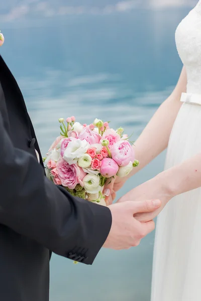 Bride and groom hold each others hands — Stock Photo, Image