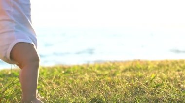 İlk adımlar atmaya çalışan bebek tutan anne