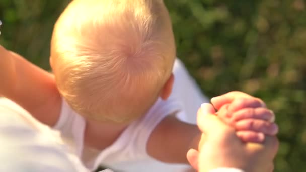 Mãe segurando o bebê que tenta dar os primeiros passos — Vídeo de Stock