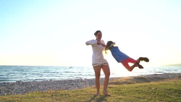 Mother twists daughter in her arms — Stock Video