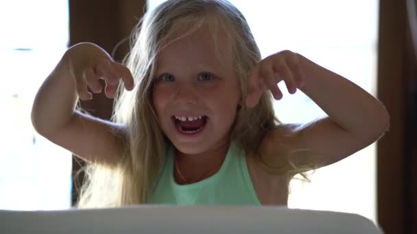 Гарна маленька дівчинка лякає за веселощі, що вистрибують з приховування — стокове відео