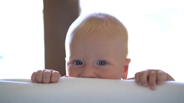 Lindo bebé asomándose fuera de su escondite — Vídeo de stock