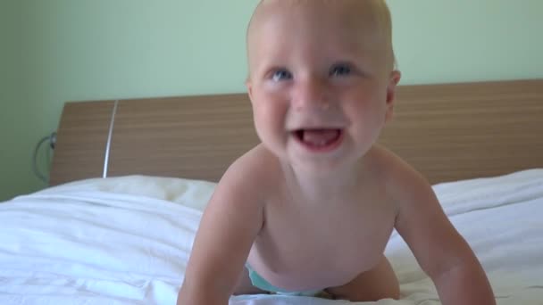 Niedliches Baby krabbelt auf dem Bett — Stockvideo