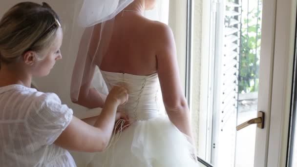 Demoiselle d'honneur aide la mariée à porter une robe — Video