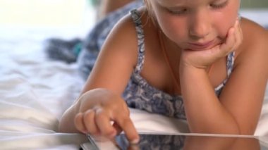 küçük sevimli kız bir oyun tablet üzerinde çalış.