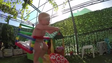 ilk kez bir salıncak üzerinde yedi aylık yürümeye başlayan çocuk