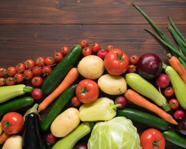 Koyu ahşap yüzeyde sebze çeşitleri, üst manzara.