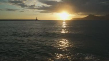 Gün batımında deniz feneri ve dokulu bulutlarla muhteşem gökyüzü.