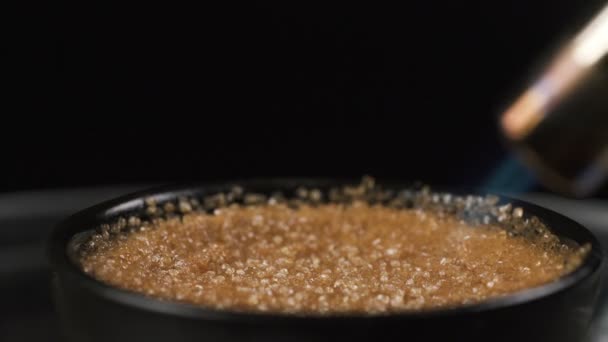 Azúcar caramelizante en la parte superior del postre de crema brulee utilizando la antorcha de gas — Vídeo de stock
