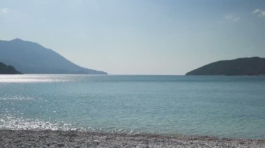 Şişme halkayla sahilde yürürken dizüstü bilgisayarda çalışan iş adamı.