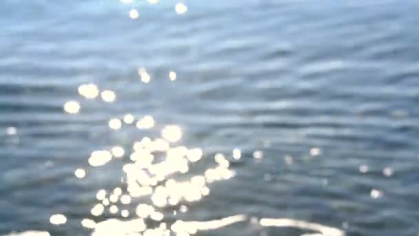 Desenfoque ondulaciones y deslumbramiento del sol en el agua — Vídeos de Stock