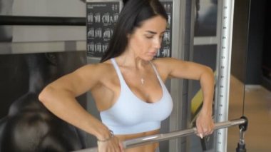 Spor salonunda kas egzersizi yaparken güzel bir kadın sporcunun portresi. Spor salonunda omuz egzersizi..